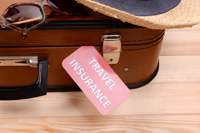 Suitcase and tourist stuff with inscription travel insurance